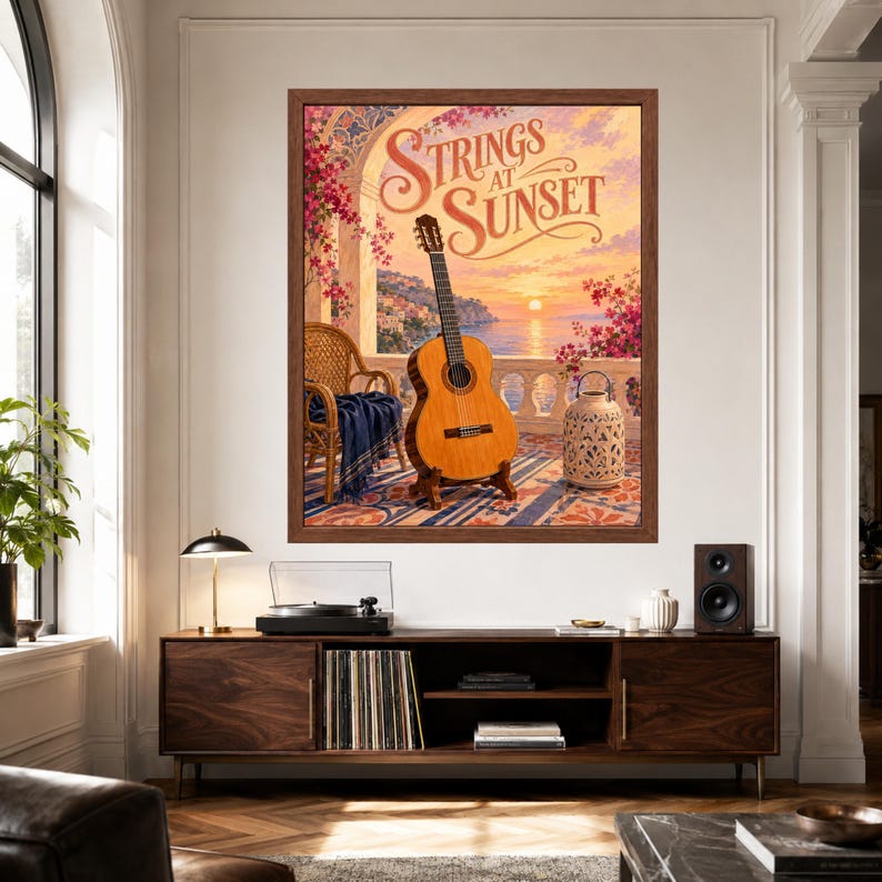 May include: A framed wall art print titled Strings at Sunset, featuring a classical guitar on a stand, a wicker chair with a blue throw, and a decorative lantern on a balcony overlooking a coastal sunset with pink flowers and ocean views.