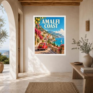 May include: A framed travel poster featuring a red vintage car on a coastal road along the Amalfi Coast, Italy. The scene includes vibrant pink bougainvillea, yellow lemons, blue sea, and distant mountains under a clear sky with the text Amalfi Coast Italy.