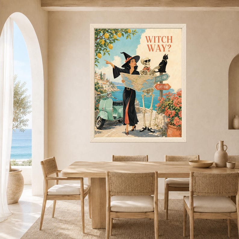Puede incluir: Una impresi&oacute;n art&iacute;stica enmarcada titulada WITCH WAY? que muestra a una bruja con vestido negro y un esqueleto con gafas de sol mirando un mapa. Se ven un scooter verde claro, un gato negro, limoneros y se&ntilde;ales de Coast Road y Cliff Road.