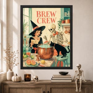 May include: A framed wall art print titled BREW CREW featuring a witch in a black hat and a skeleton wearing a red bowtie standing behind a copper cauldron. A black cat sits on a stool next to the cauldron, which contains a light blue liquid.