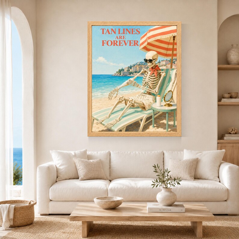 May include: A framed wall art print featuring a skeleton wearing sunglasses and a red neckerchief, lounging on a striped beach chair under a red and white umbrella. The text TAN LINES ARE FOREVER is printed in red above the skeleton on a beach.