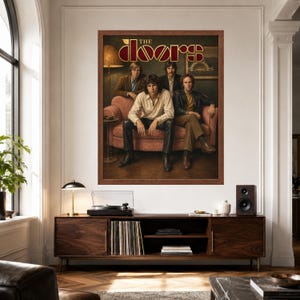 May include: A framed wall poster featuring the rock band The Doors. The image shows four band members sitting on a pink sofa in a dimly lit room. The text THE DOORS is printed in a stylized gold and red font at the top of the rectangular print.