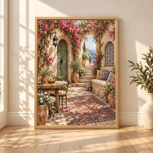 Framed Mediterranean courtyard wall art with pink bougainvillea, olive trees, weathered green door, terracotta pots, blue tile details, patterned rug and a coastal sea view through a stone archway.