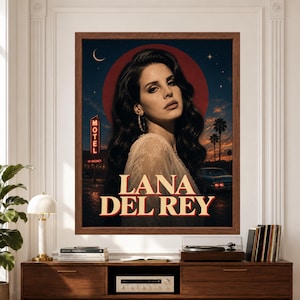 Framed Lana Del Rey wall art featuring a vintage-inspired music portrait against a dark blue night sky with crescent moon, stars, red halo, glowing motel sign, palm trees and a classic car above bold Lana Del Rey typography.