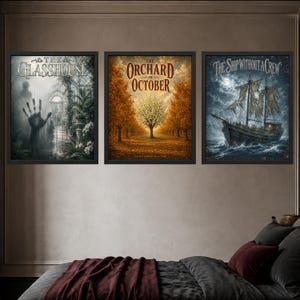 May include: Three framed wall art prints featuring dark, atmospheric illustrations. The left print shows a handprint on glass with the text The Glasshouse. The center print depicts an autumn orchard titled The Orchard in October. The right print shows a ghost ship titled The Ship Without a Crew.