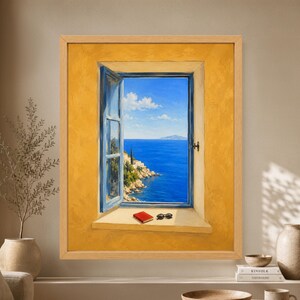 Framed Mediterranean window wall art showing an open blue window in a warm yellow plaster wall overlooking a vivid blue sea, rocky Greek island coastline and distant island under a clear summer sky.