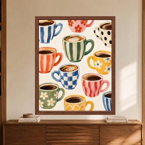 Op de afbeelding: Een ingelijste muurkunstprint met een patroon van diverse koffiemokken op een cr&egrave;mekleurige achtergrond. De mokken tonen uiteenlopende ontwerpen, waaronder blauwe strepen, roze bloemen, zwarte stippen, groene strepen, gele madeliefjes en ruitjes.