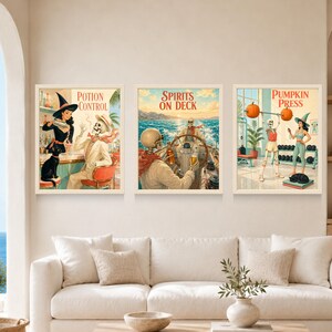 May include: Three framed rectangular wall art prints featuring vintage-style illustrations. The left print shows a witch and a skeleton at a bar with the text Potion Control. The center print shows skeletons on a boat with the text Spirits on Deck. The right print shows a skeleton and a witch in a gym with the text Pumpkin Press.