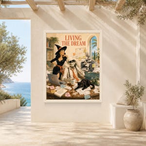 May include: A framed wall art print titled LIVING THE DREAM featuring a pin-up style person in a witch hat standing behind a skeleton wearing sunglasses and a tie at a cluttered office desk with a black cat, papers, and a computer.