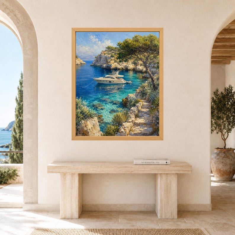 May include: A framed wall art print depicting a white motor yacht anchored in a clear blue Mediterranean cove. The scene features rocky cliffs, lush green trees, and a stone pathway leading toward the water under a bright, partly cloudy sky.