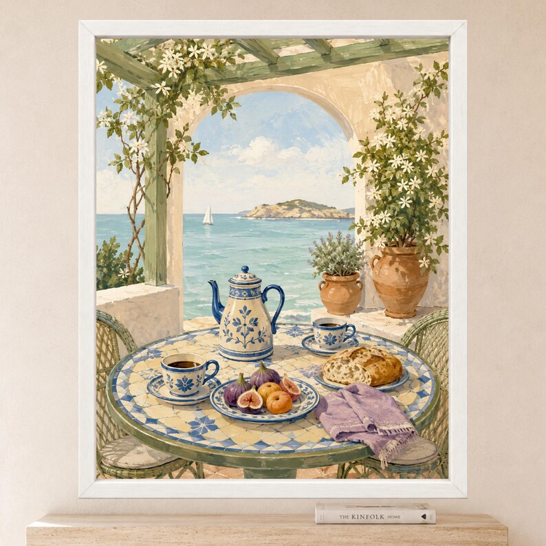 May include: A framed painting depicting a Mediterranean terrace with a tiled table set for tea. The table holds a blue and white teapot, two matching cups, a plate of figs and peaches, a loaf of bread, and a purple napkin. A sailboat is visible at sea.
