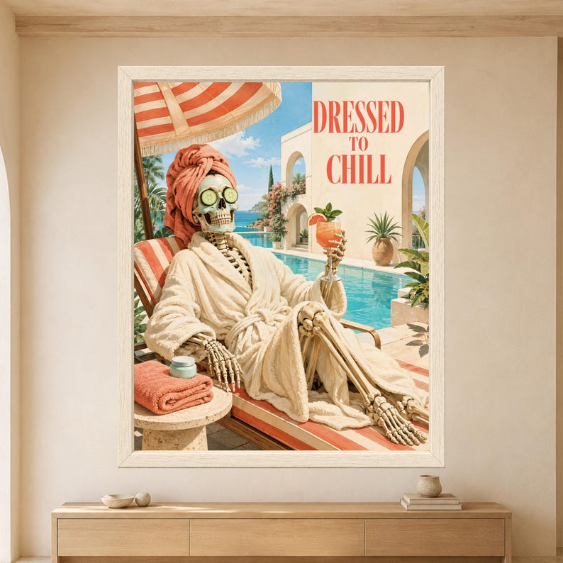 Framed Dressed to Chill skeleton wall art featuring a skeleton relaxing beside a turquoise pool in a fluffy bathrobe, coral towel turban, cucumber eye slices and tropical cocktail.