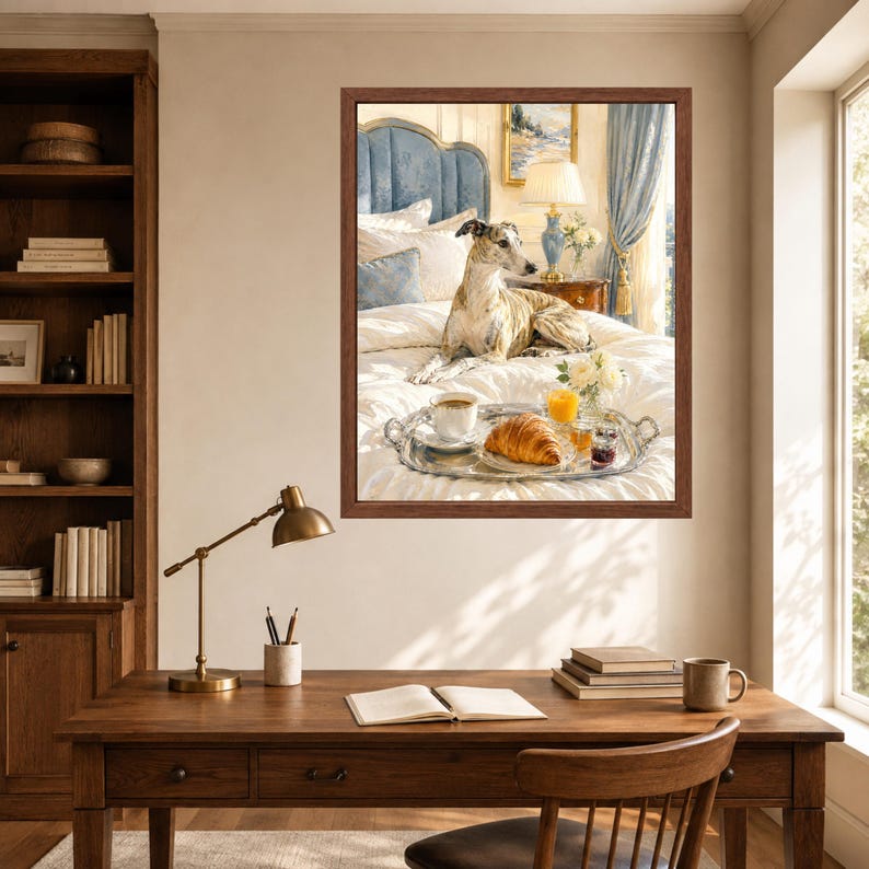 May include: A framed wall art print depicting a brindle greyhound resting on a white bed with a silver tray holding a croissant, a cup of coffee, and a glass of orange juice. The scene includes a blue headboard, a lamp, and curtains.