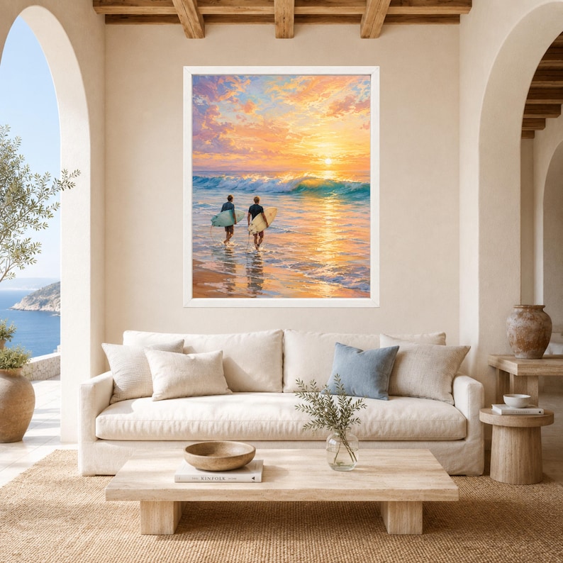 May include: A framed wall art print depicting two surfers walking into the ocean at sunset. The scene features golden and orange clouds, a breaking wave, and the surfers carrying surfboards. The artwork is displayed in a white frame.