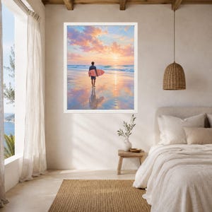 May include: A framed wall art print depicting a person walking on a wet sandy beach at sunset while carrying a pink surfboard. The sky is filled with soft orange and purple clouds, and the ocean waves are visible in the background.
