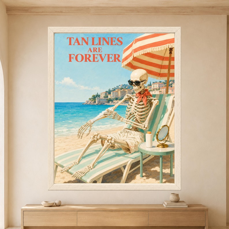 Framed Tan Lines Are Forever skeleton wall art featuring a sunglasses-wearing skeleton relaxing on a striped beach lounger beneath a coral parasol beside a turquoise Mediterranean coastline.