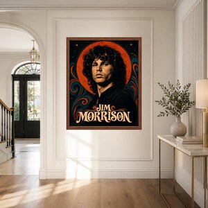 May include: A rectangular framed wall art print featuring a portrait of Jim Morrison with curly dark hair. The background displays a large orange circular sun motif surrounded by dark blue and orange swirling patterns. The text JIM MORRISON is printed.