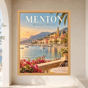 May include: A framed wall art print featuring a coastal scene of Menton on the French Riviera. The image displays a harbor with boats, colorful buildings, mountains, and bright pink bougainvillea flowers in the foreground. Text reads MENTON.