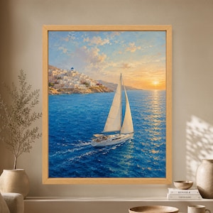 Framed Greek island wall art showing a white sailboat crossing deep blue Aegean water at sunset beside whitewashed hillside houses and a blue-domed church.