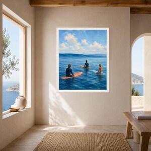 May include: A framed wall art print depicting three individuals on surfboards in the middle of a deep blue ocean. The scene features a clear sky with scattered white clouds above a calm sea, with one person on an orange board and two others.