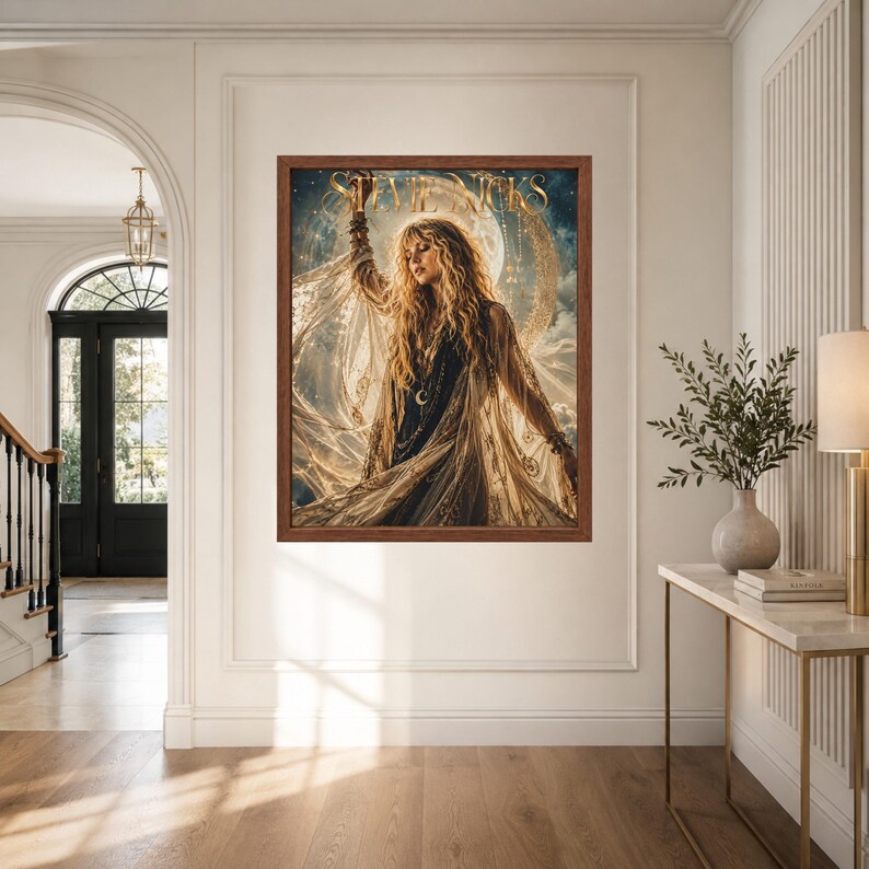 May include: A framed wall art print featuring a portrait of Stevie Nicks with long blonde hair, wearing a dark top and a flowing, sheer, gold-toned shawl. The background displays a large moon and celestial elements with the text Stevie Nicks.