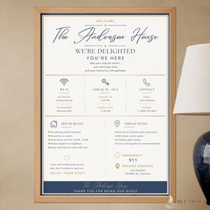 Puede incluir: Un letrero de bienvenida enmarcado para The Anderson House con texto en azul marino y dorado sobre fondo blanco. Incluye secciones para Wi-Fi, horarios de entrada y salida, contactos, reglas de la casa, recomendaciones y datos de emergencia.