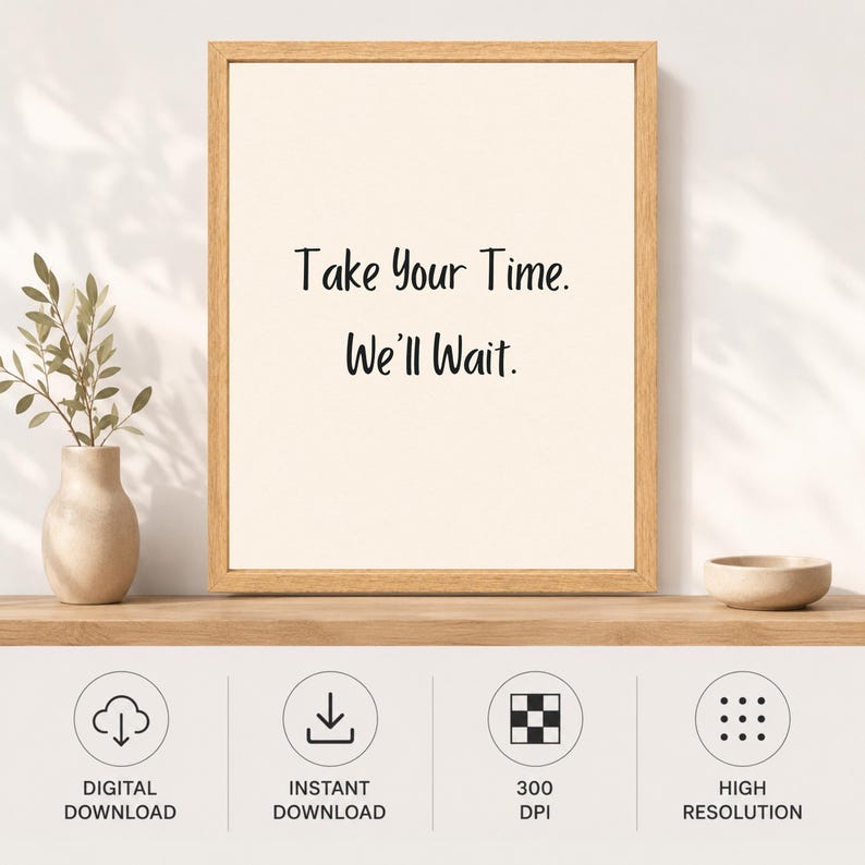 May include: A framed wall art print featuring a light cream background with the black text "Take Your Time. We'll Wait." centered in the frame. The frame is made of light-colored wood. Below the frame are four circular icons for digital download.