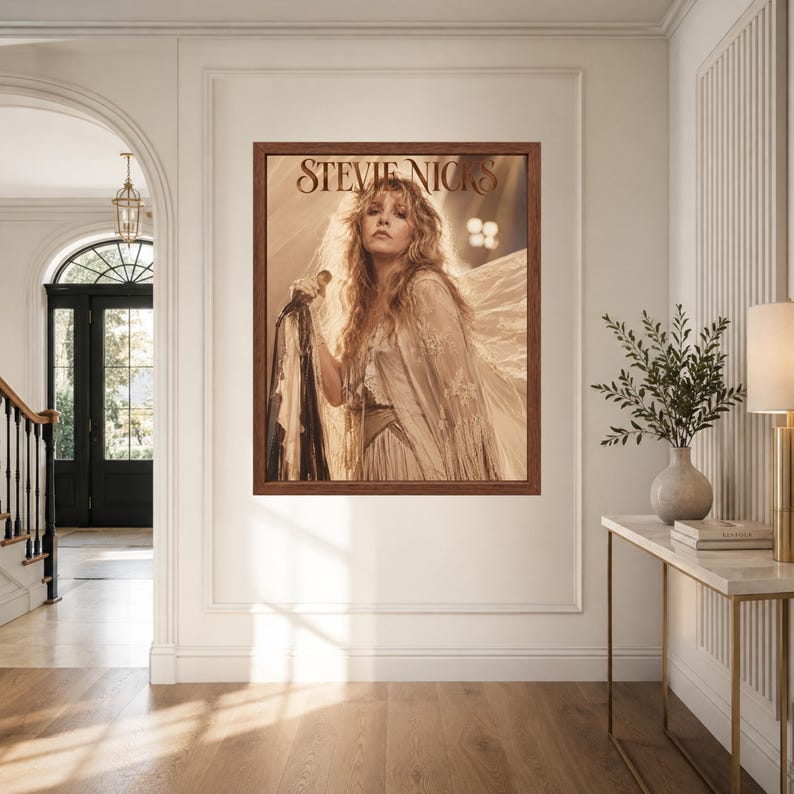 Może przedstawiać: Oprawiony wydruk ścienny przedstawiający portret Stevie Nicks w odcieniach sepii, trzymającej mikrofon. Postać ma długie, falowane włosy i ubrana jest w str&oacute;j z frędzlami z przezroczystego materiału. Napis STEVIE NICKS znajduje się u g&oacute;ry.