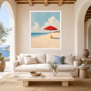 May include: A framed wall art print depicting a beach scene with a bright red beach umbrella and a yellow tote bag resting on the sand. The painting features a clear blue sky with white clouds, a calm ocean, and a sandy shoreline in a coastal setting.