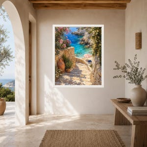 Peut inclure: Une impression d'art encadr&eacute;e repr&eacute;sentant une sc&egrave;ne c&ocirc;ti&egrave;re m&eacute;diterran&eacute;enne avec des marches en pierre menant &agrave; une baie turquoise. L'image montre un pot en terre cuite, des fleurs de laurier-rose et un petit parasol ray&eacute; rouge et blanc.