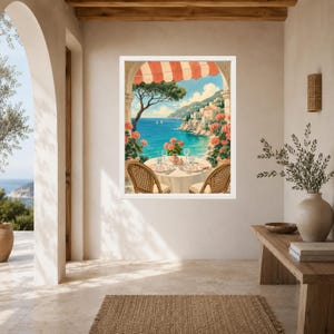 May include: A framed wall art print depicting a coastal scene with a round table set for two under a red and white striped awning. The view features a blue sea, distant cliffs with white buildings, and potted pink flowers framing the balcony.
