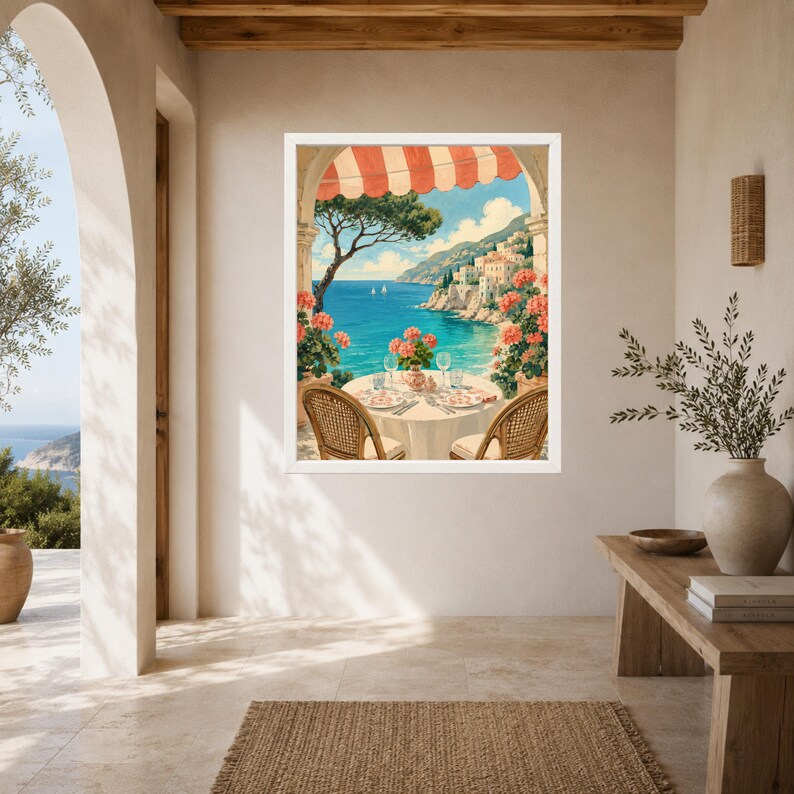 May include: A framed wall art print depicting a coastal scene with a round table set for two under a red and white striped awning. The view features a blue sea, distant cliffs with white buildings, and potted pink flowers framing the balcony.