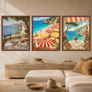 Op de afbeelding: Een set van drie ingelijste wandkunstwerken met mediterrane kusttaferelen. Links een gedekte tafel met uitzicht op zee. In het midden een zandstrand met rood-geel gestreepte parasols. Rechts een balkon met een eettafel, bloemen en een gestreepte zonwering.
