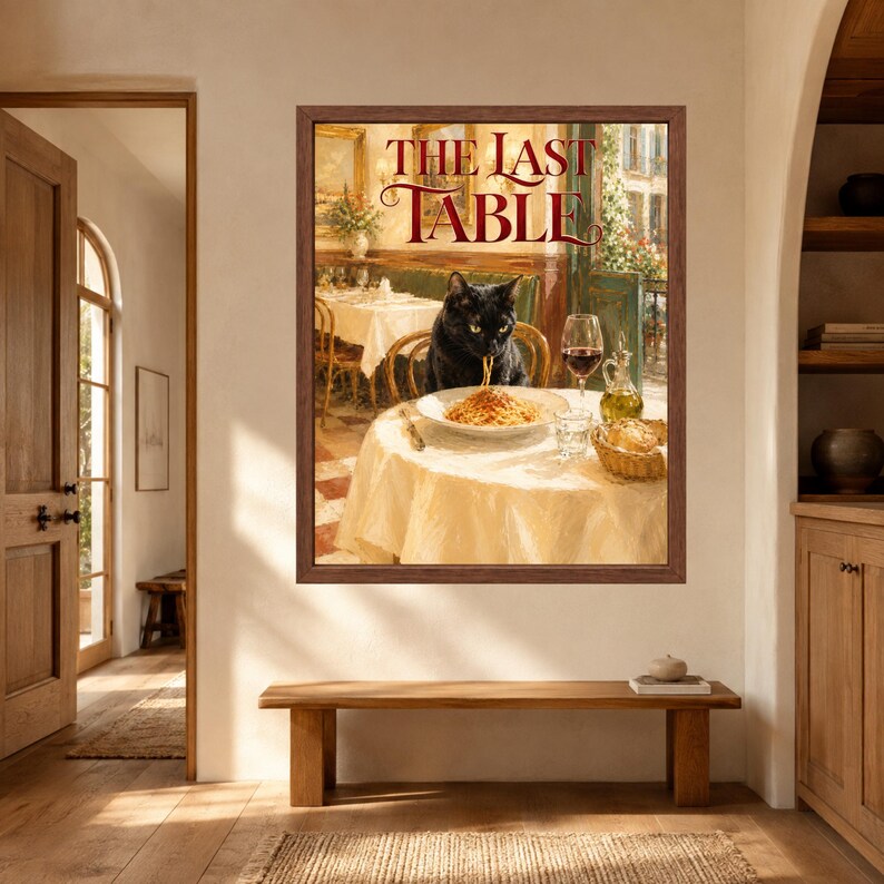 Pu&ograve; includere: Una stampa d'arte incorniciata intitolata THE LAST TABLE che raffigura un gatto nero seduto a un tavolo rotondo coperto da una tovaglia bianca, che mangia spaghetti da un piatto bianco, con un calice di vino e una bottiglia d'olio d'oliva.