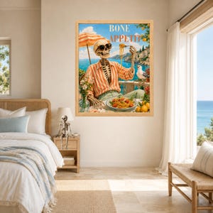 Peut inclure: Une impression d'art encadr&eacute;e repr&eacute;sentant un squelette portant des lunettes de soleil et une chemise ray&eacute;e orange, mangeant des p&acirc;tes &agrave; une table en bord de mer. Le texte BONE APPETIT est inscrit en haut. La sc&egrave;ne inclut un parasol, un go&eacute;land et des citrons.