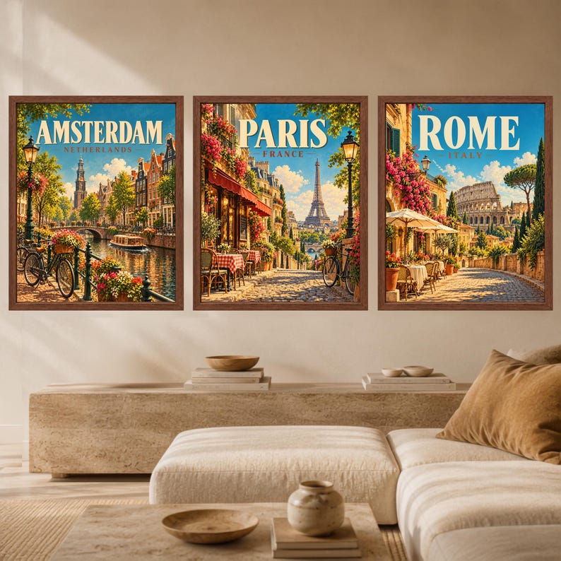 May include: Three framed wall art prints depicting city scenes. The left print shows Amsterdam with a canal, bicycle, and buildings. The center print shows Paris with the Eiffel Tower and a street cafe. The right print shows Rome with the Colosseum.