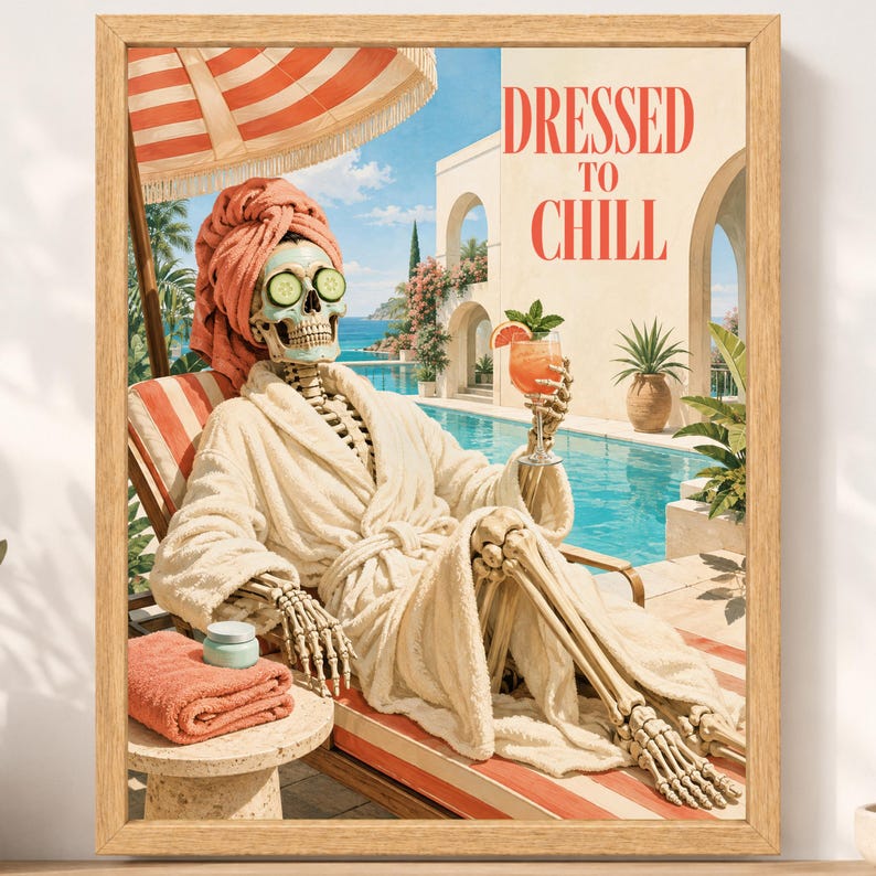 May include: A framed wall art print featuring a skeleton wearing a peach-colored towel wrap and robe, with cucumber slices over its eyes, lounging by a pool under a striped umbrella. The skeleton holds a cocktail, with the text DRESSED TO CHILL.