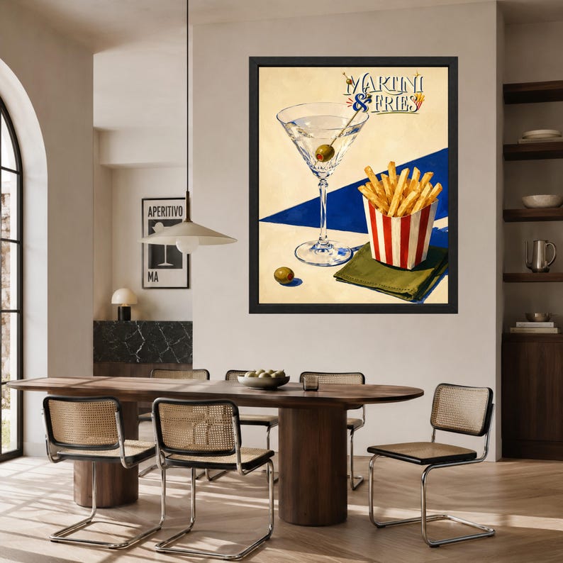 May include: A framed wall art print featuring a martini glass with an olive and a red and white striped container of french fries. The text MARTINI & FRIES is printed at the top. The background is a cream color with a bold blue diagonal stripe.