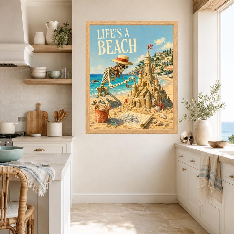 Puede incluir: Una impresi&oacute;n art&iacute;stica enmarcada que muestra un esqueleto con sombrero de paja y bufanda roja construyendo un castillo de arena detallado en una playa. El texto LIFE'S A BEACH aparece en letras grandes arriba. Incluye un cubo rojo y un plano.