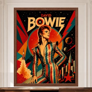 May include: A framed poster featuring a stylised illustration of David Bowie in a red, white, and blue striped jumpsuit. The background displays a space theme with a rocket, planets, a city skyline, and the text DAVID BOWIE in bold lettering.