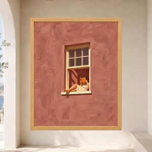 May include: A framed wall art print featuring a textured terracotta-colored wall with a single window. A person sits in the window frame reading an orange book. The artwork is enclosed in a light-toned wooden frame, displaying a scene of relaxation.