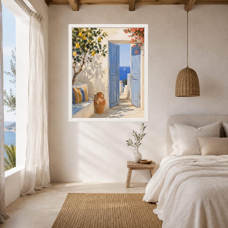 May include: A framed wall art print depicting a Mediterranean scene with an open blue door, a lemon tree, a terracotta vase, and a striped cushion on a stone bench. The artwork features a bright coastal view with a distant sailboat on the blue sea.