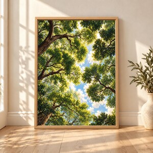 Framed tree canopy wall art showing tall green trees viewed from below, with twisting branches, sunlit leaves and patches of bright blue sky between the foliage.
