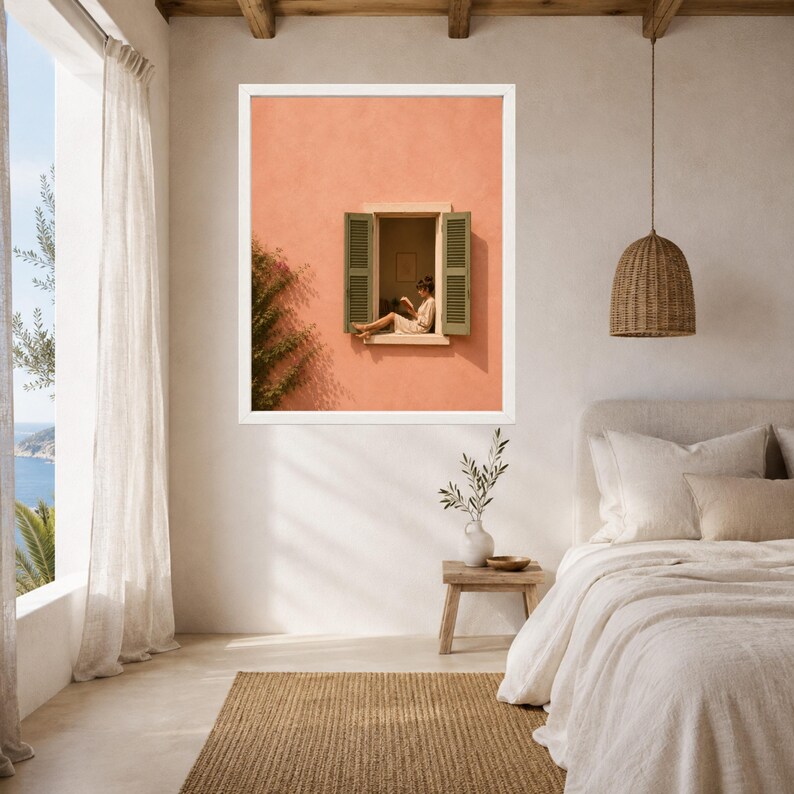 May include: A framed wall art print featuring a peach-colored stucco wall with an open window. Green shutters frame the window where a person sits reading. A leafy green vine grows up the side of the wall, adding a natural element to the scene.