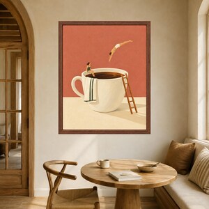 May include: A framed wall art print featuring a large white coffee cup against a terracotta background. A person in a green swimsuit sits on the rim with a towel, while another person dives into the dark liquid. A wooden ladder leans against the cup.