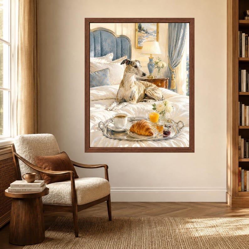 May include: A framed wall art print depicting a brindle whippet dog resting on a white bed with a silver breakfast tray featuring a croissant, a cup of coffee, a glass of orange juice, and a small jar of jam, set in a bedroom with blue accents.
