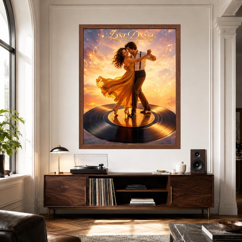 May include: A framed wall art print titled Last Dance featuring a couple dancing on a large black vinyl record against a sunset sky with musical notes. The artwork is displayed in a brown frame on a white wall above a wooden media console.