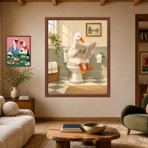 May include: A framed wall art print featuring a white duck with orange feet sitting on a white toilet reading a newspaper in a bathroom with green wainscoting and checkered floors, alongside a smaller framed print of two swans dining at a table.