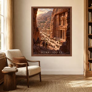 May include: A framed wall art print depicting the ancient city of Petra with carved stone architecture, desert cliffs, and figures with camels in a marketplace setting. The text PETRA 100 CE is printed in white at the bottom of the image.