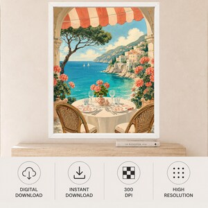 May include: A framed wall art print depicting a coastal scene viewed from a balcony with a red and white striped awning. A round table with two wicker chairs, plates, and glasses overlooks a blue sea, a rocky coastline, and white buildings.